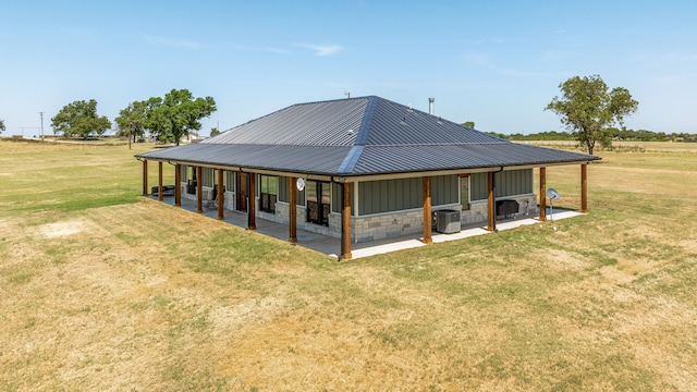 rear view of property featuring a patio, a yard, central air condition unit, and a rural view