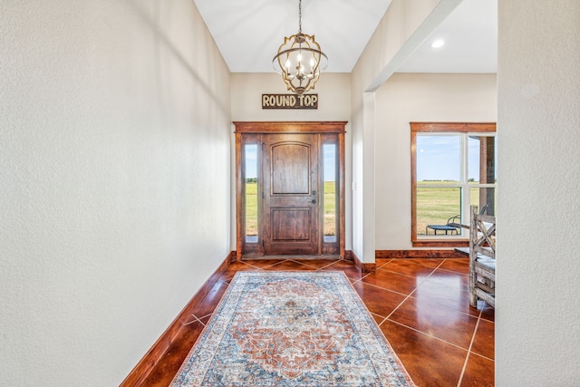 tiled foyer entrance with a notable chandelier