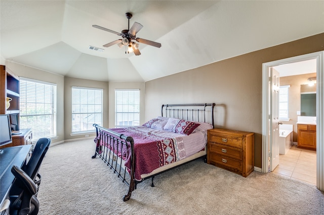 carpeted bedroom featuring multiple windows, ensuite bath, lofted ceiling, and ceiling fan