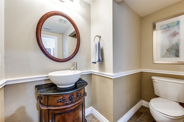 bathroom featuring toilet, vanity, and tile patterned flooring