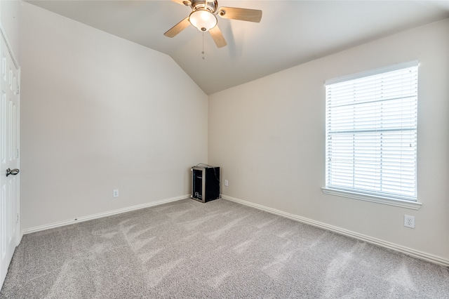 carpeted empty room featuring vaulted ceiling and ceiling fan