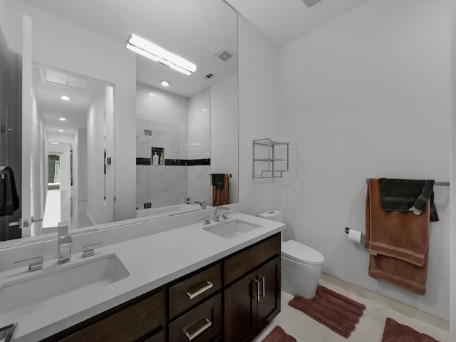 bathroom with toilet, vanity, tiled shower, and tile patterned floors