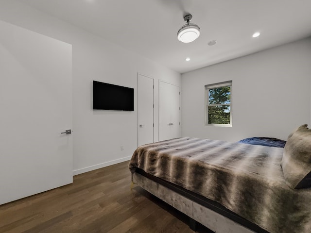 bedroom with dark hardwood / wood-style floors