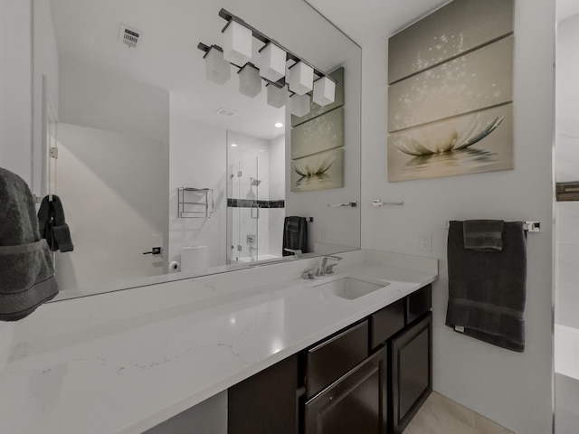 bathroom featuring tile patterned flooring, an enclosed shower, and vanity