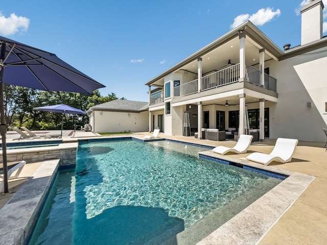 view of swimming pool featuring ceiling fan and a patio