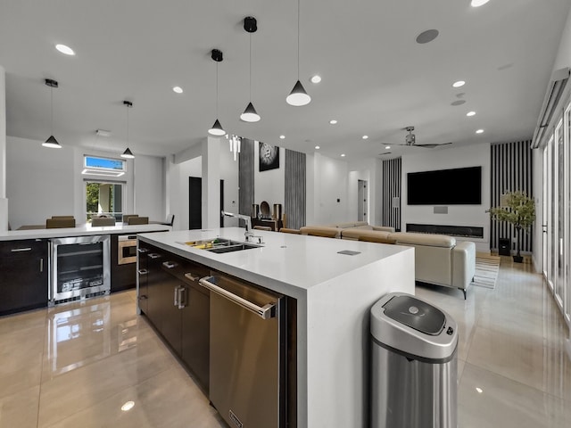 kitchen featuring sink, an island with sink, pendant lighting, light tile patterned flooring, and beverage cooler