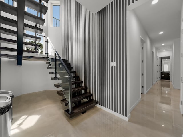 staircase with tile patterned flooring and a high ceiling