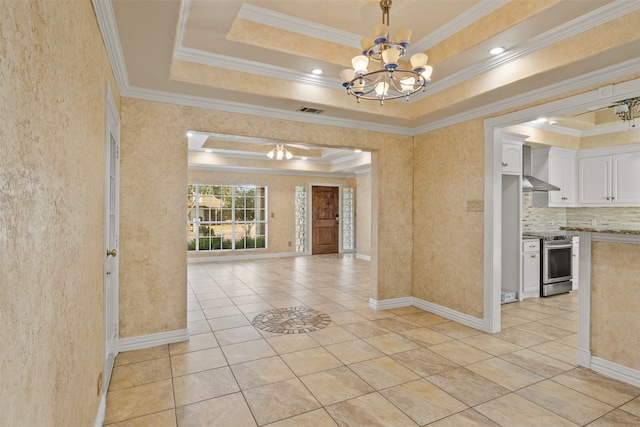 interior space featuring light tile patterned floors, an inviting chandelier, a tray ceiling, and ornamental molding