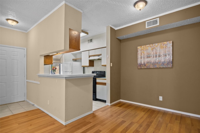 kitchen featuring white cabinetry, black / electric stove, white refrigerator, light hardwood / wood-style floors, and kitchen peninsula