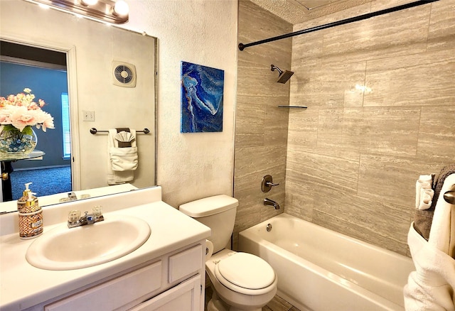 full bathroom with a textured ceiling, toilet, tiled shower / bath, and vanity