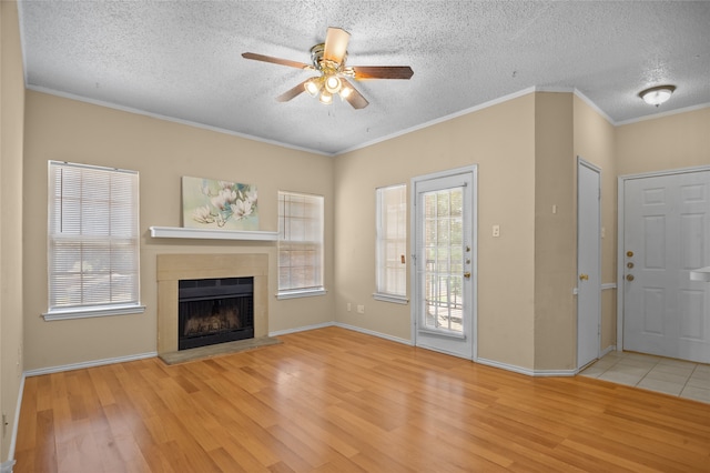 unfurnished living room with ceiling fan, light wood-type flooring, and a textured ceiling