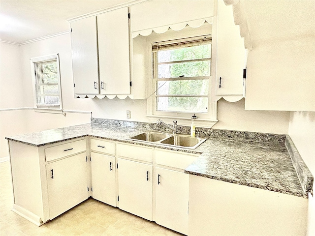 kitchen with sink, a healthy amount of sunlight, light tile patterned floors, and kitchen peninsula