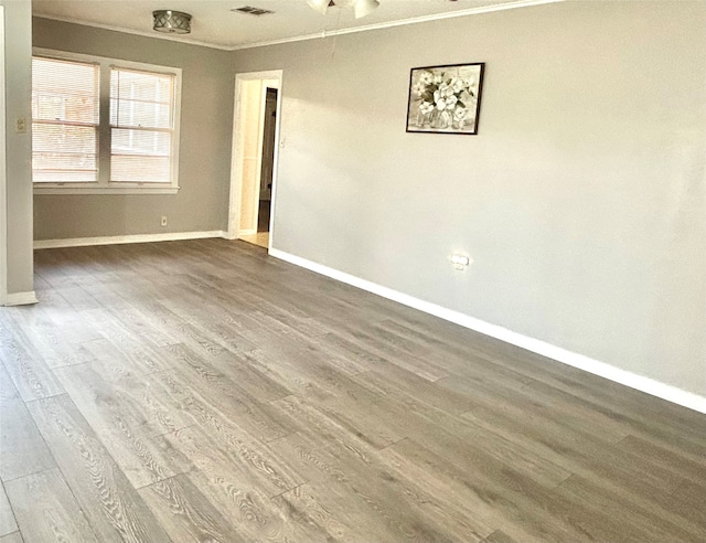 unfurnished room featuring crown molding and hardwood / wood-style floors