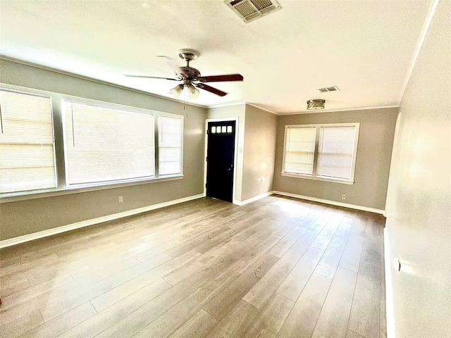 unfurnished living room featuring light wood-type flooring, ornamental molding, and ceiling fan