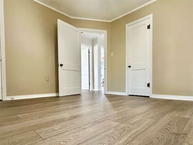 spare room featuring light hardwood / wood-style flooring and crown molding