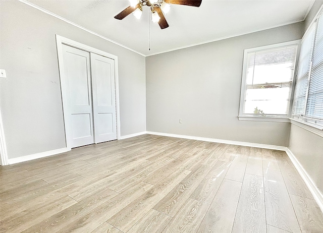 unfurnished bedroom with light hardwood / wood-style floors, crown molding, ceiling fan, and a closet