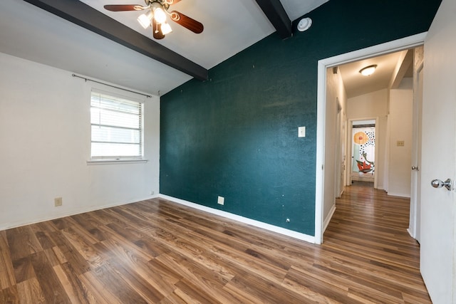 empty room featuring lofted ceiling with beams, wood-type flooring, and ceiling fan