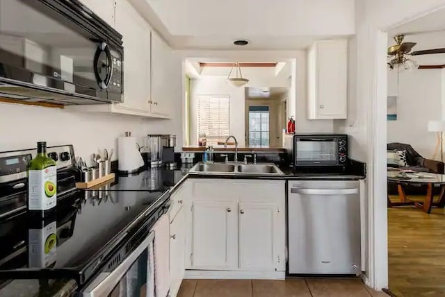 kitchen with sink, hardwood / wood-style flooring, stainless steel dishwasher, white cabinetry, and range with electric cooktop