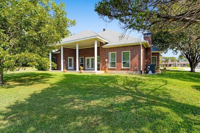 rear view of property with a lawn and central AC