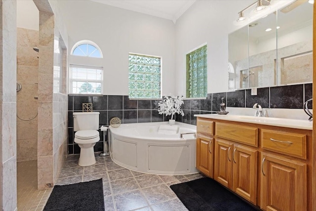 full bathroom with vanity, crown molding, tile walls, shower with separate bathtub, and toilet