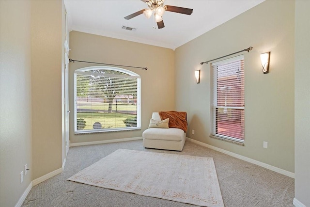 sitting room featuring ceiling fan, light carpet, and a wealth of natural light