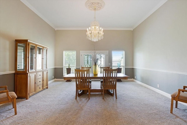 dining room with ornamental molding, light carpet, a towering ceiling, and a chandelier