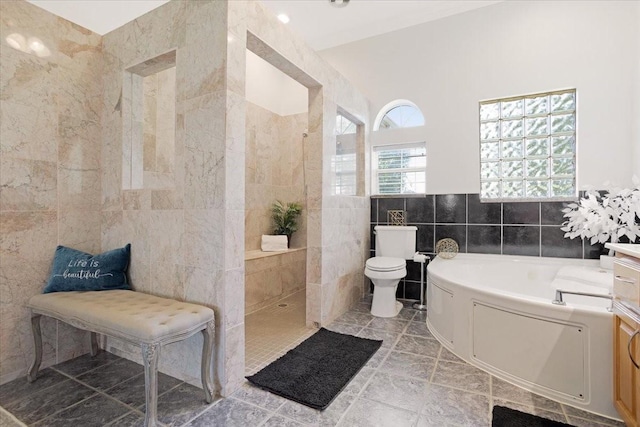 full bathroom featuring vanity, separate shower and tub, toilet, and tile walls