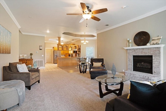 carpeted living room featuring a fireplace, ceiling fan with notable chandelier, and ornamental molding