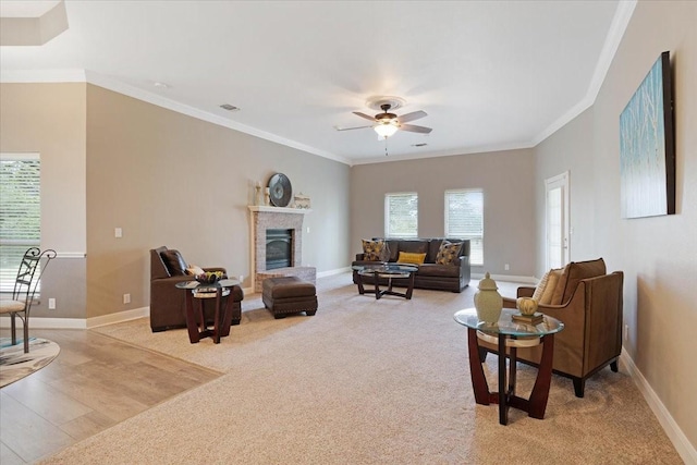 living room featuring light carpet, ceiling fan, and ornamental molding