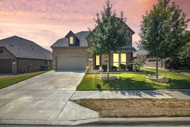 view of front of house featuring brick siding, concrete driveway, a garage, stone siding, and a front lawn