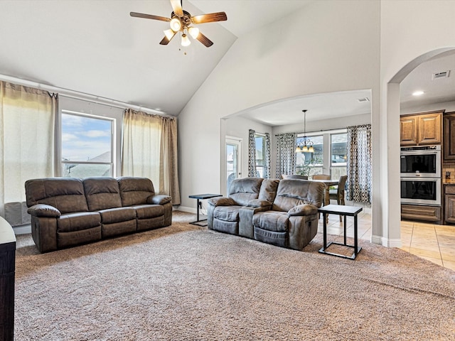 living room with arched walkways, light tile patterned flooring, visible vents, and light colored carpet