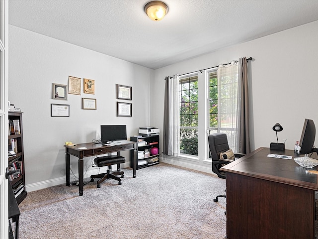 carpeted office space featuring baseboards and a textured ceiling