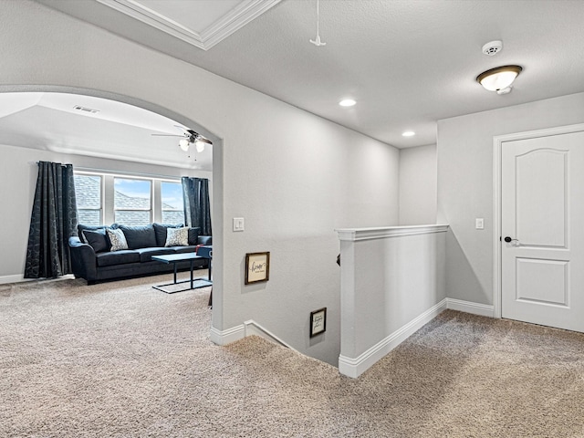 corridor with visible vents, arched walkways, carpet flooring, and an upstairs landing