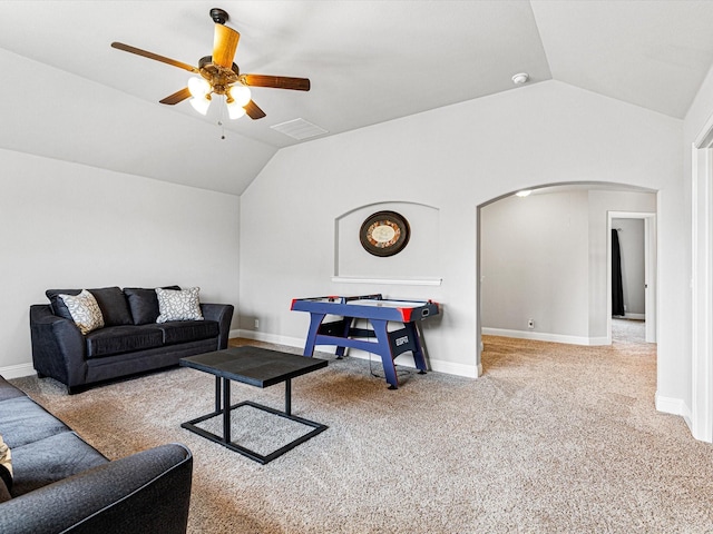 living area with ceiling fan, carpet, arched walkways, and vaulted ceiling