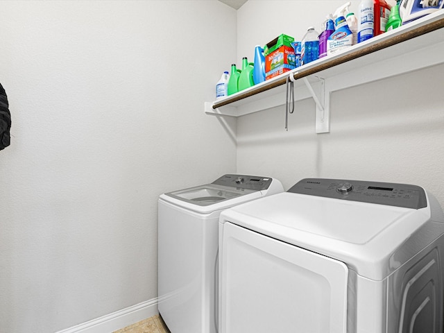 washroom featuring laundry area, washing machine and dryer, and baseboards