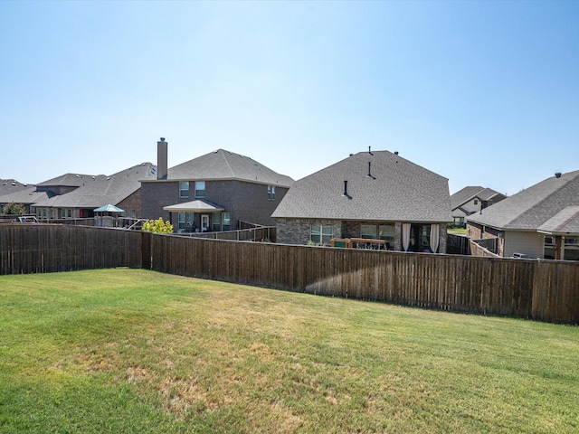 view of yard featuring a fenced backyard and a residential view