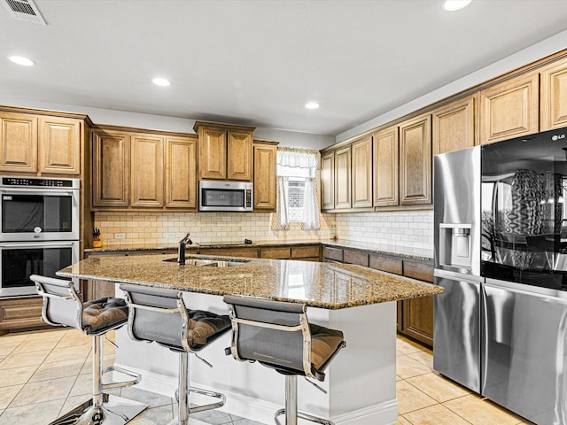 kitchen featuring light tile patterned floors, visible vents, dark stone counters, stainless steel appliances, and a sink