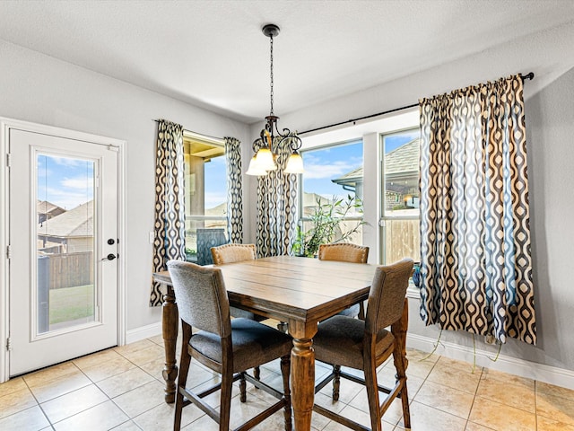 dining space featuring baseboards, a textured ceiling, and light tile patterned flooring