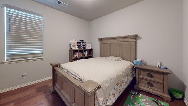 bedroom with dark hardwood / wood-style floors