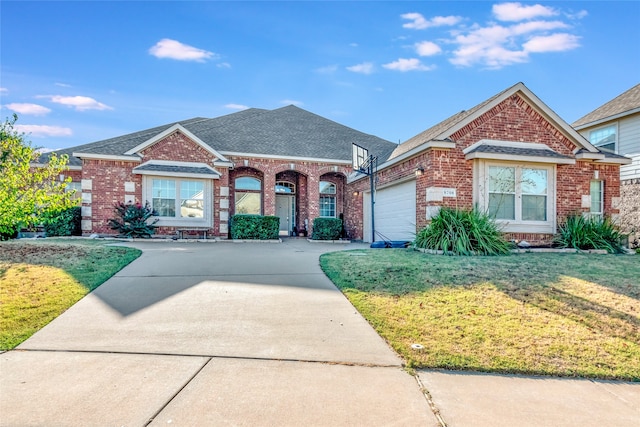 view of front of property featuring a garage, brick siding, a shingled roof, driveway, and a front yard