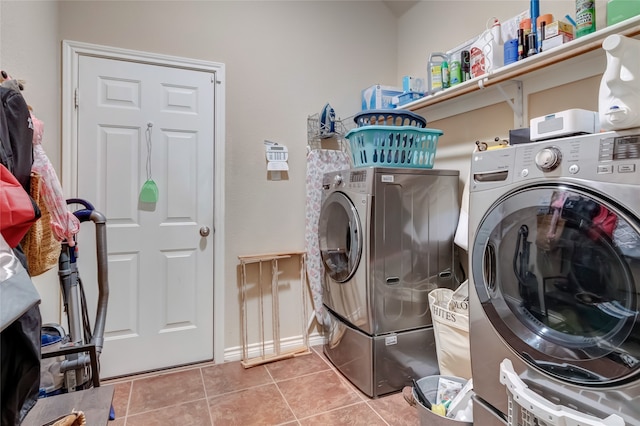 clothes washing area with laundry area, tile patterned flooring, baseboards, and washer and dryer