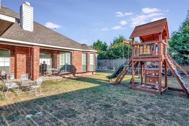 view of playground with a yard and a patio area