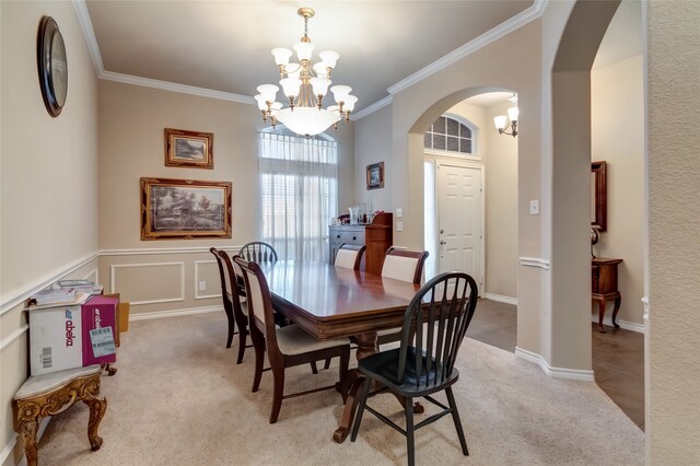 dining space featuring ornamental molding, light colored carpet, and a notable chandelier