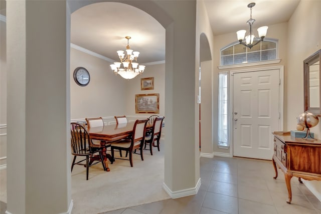 entryway featuring crown molding, a healthy amount of sunlight, and an inviting chandelier