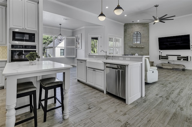 kitchen with sink, light wood-type flooring, ceiling fan, black appliances, and white cabinets