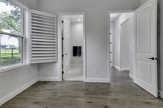 empty room with a wealth of natural light and wood-type flooring