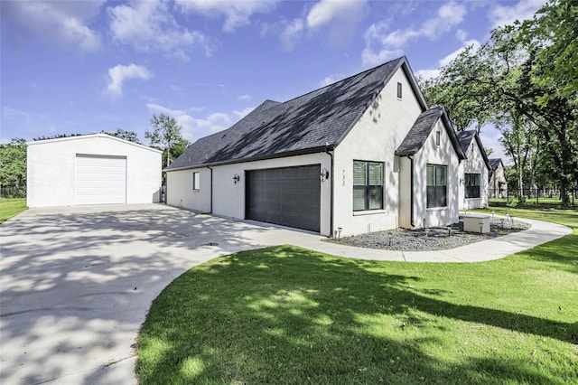 view of property exterior with a garage, a yard, and an outbuilding