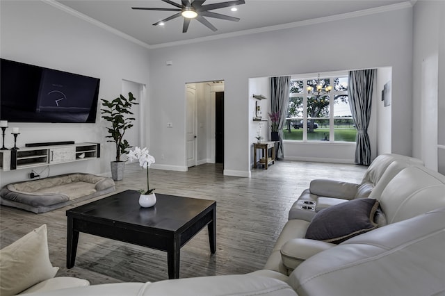 living room featuring hardwood / wood-style flooring, crown molding, and ceiling fan with notable chandelier