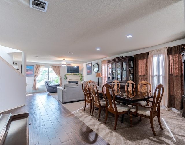 dining area featuring ceiling fan and a textured ceiling