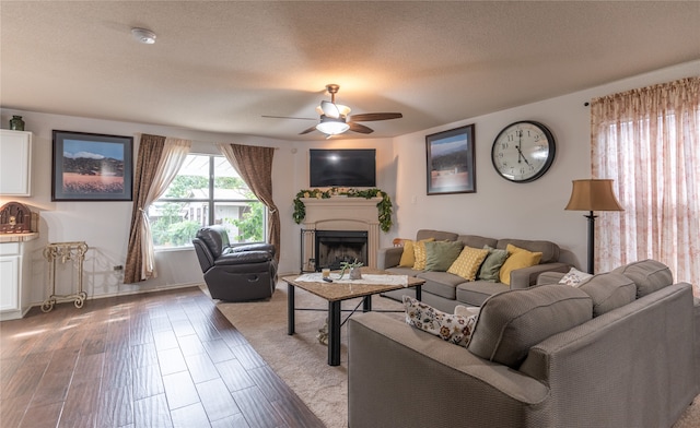 living room with hardwood / wood-style floors, ceiling fan, and a textured ceiling